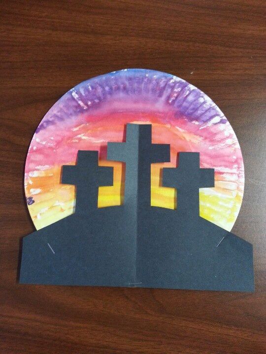A paper plate has been painted as an Easter cross scene