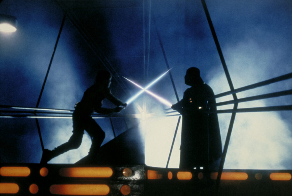 Luke Skywalker and Darth Vader battle with lightsabers.