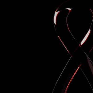 Translucent red and white glass ribbon against black background
