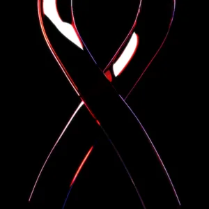 Translucent red and white glass ribbon against black background